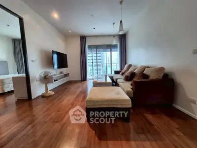 Spacious living room with modern decor and balcony view in urban apartment.