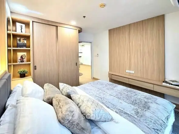 Modern bedroom with stylish wooden accents and cozy bedding in a contemporary apartment.