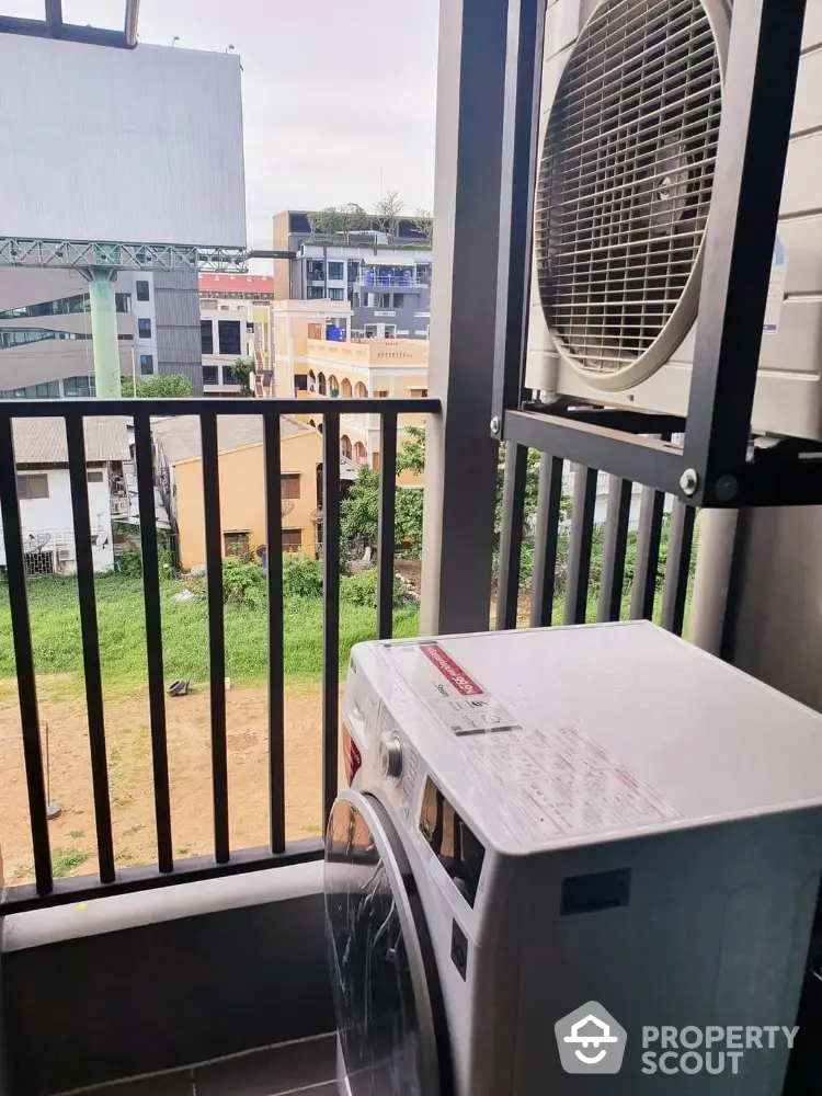 Modern balcony with washing machine and city view, perfect for urban living convenience.