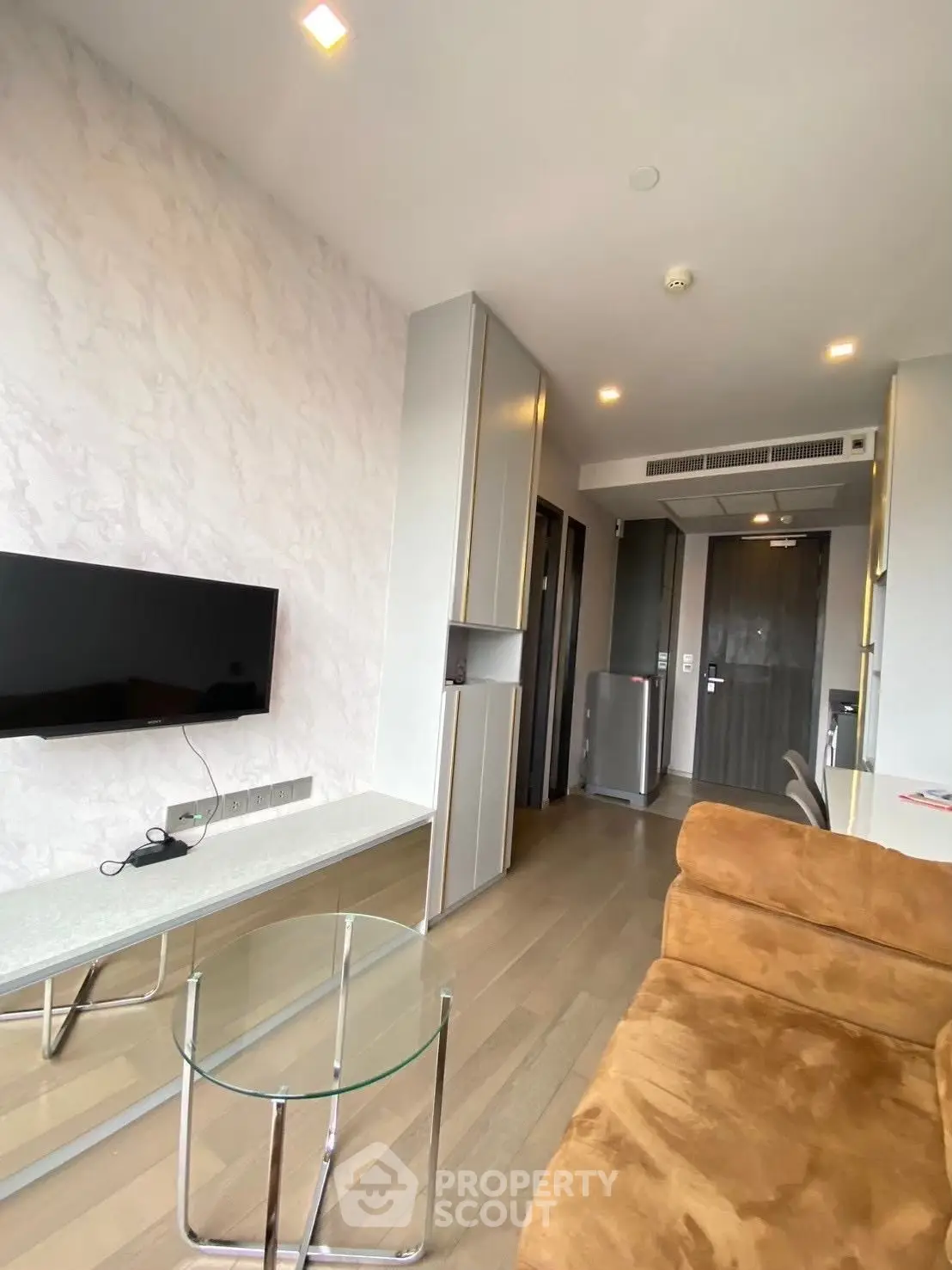 Modern living room with stylish decor and glass coffee table in a contemporary apartment.