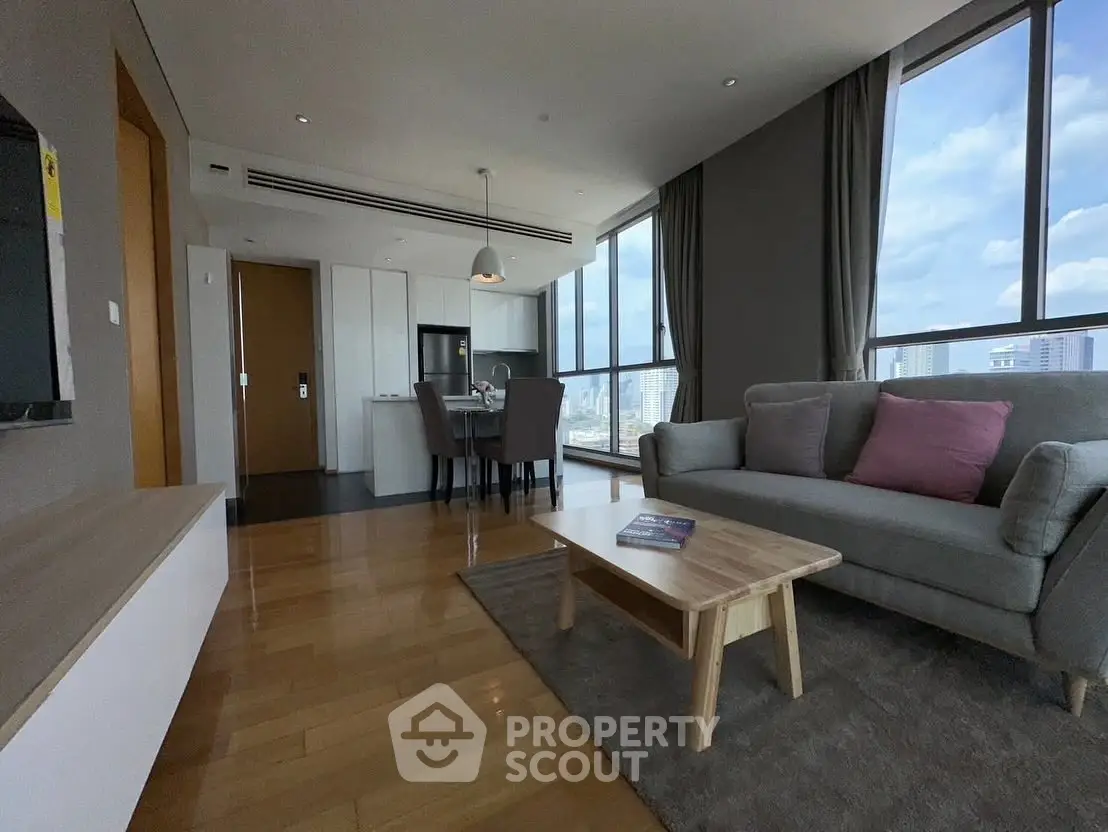 Spacious modern living room with city view and open kitchen layout.