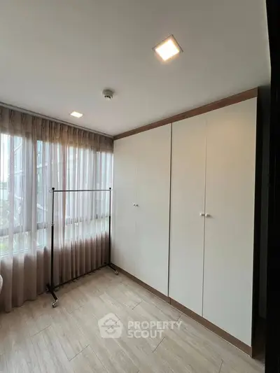 Spacious bedroom with large window and ample closet space
