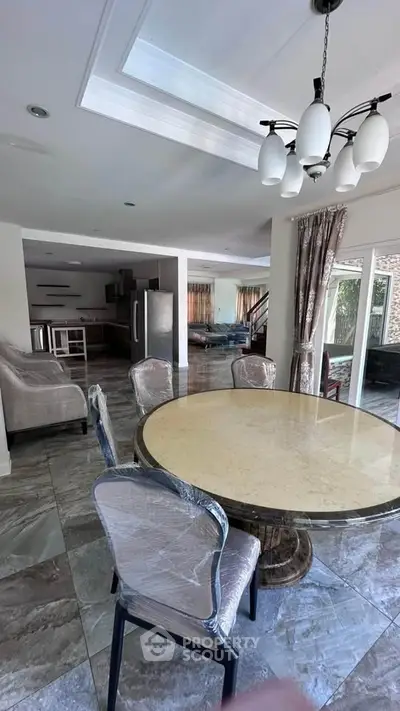 Spacious open-layout dining and living area with modern furnishings and natural light.