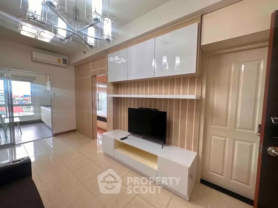 Modern living room with sleek TV unit and stylish lighting in a cozy apartment.