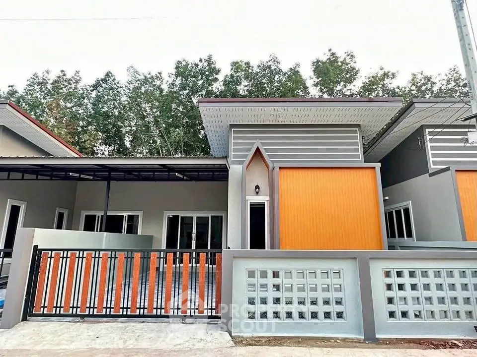 Modern single-story house with unique architectural design and vibrant orange accents.