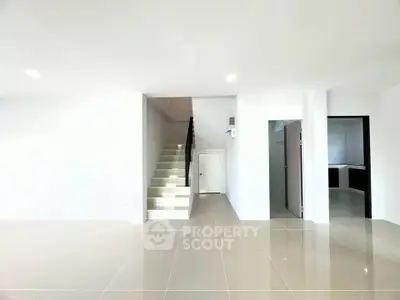 Spacious modern interior with sleek staircase and tiled flooring