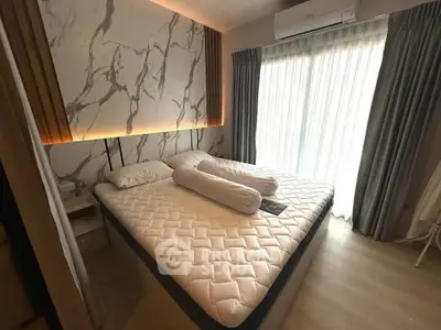 Modern bedroom with stylish marble accent wall and large window for natural light.