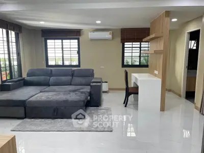 Modern living room with sleek gray sofa and stylish workspace