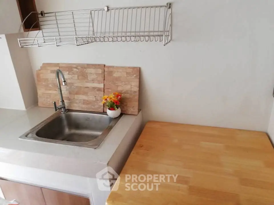 Modern kitchen with sleek countertop and stainless steel sink, perfect for culinary enthusiasts.