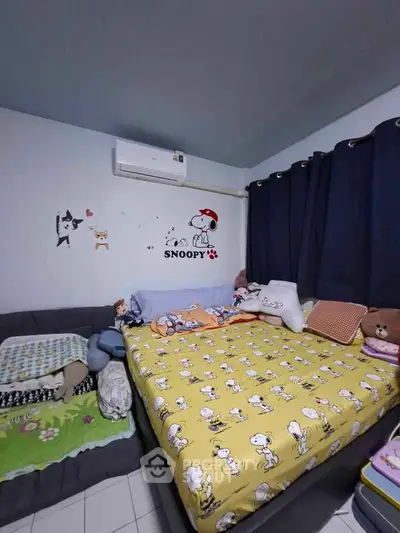 Cozy bedroom with Snoopy-themed decor and air conditioning, perfect for a comfortable living space.