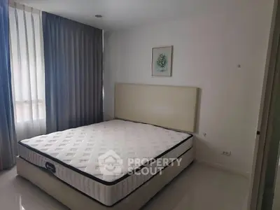 Spacious bedroom with large window and elegant decor in modern apartment