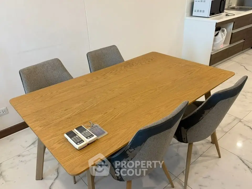 Modern dining area with wooden table and stylish chairs in a contemporary kitchen setting.