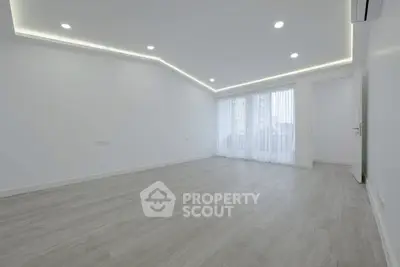 Spacious modern living room with elegant lighting and large windows.