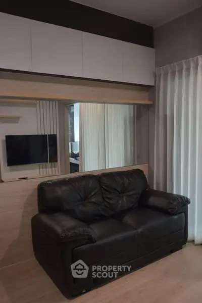 Modern living room with sleek black leather sofa and stylish wooden accents