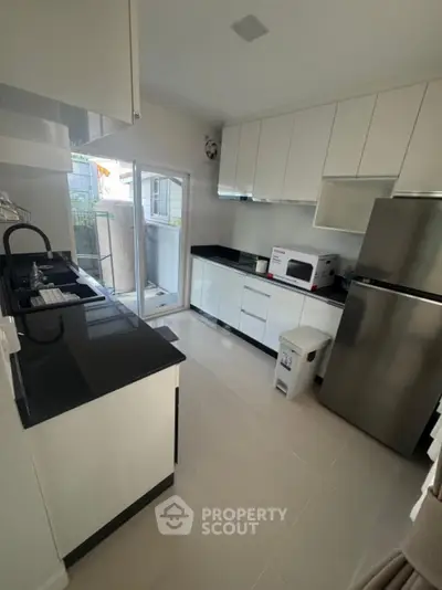 Modern kitchen with sleek white cabinets and stainless steel appliances