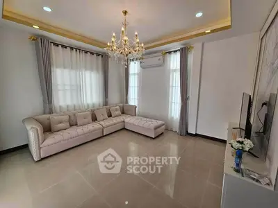 Elegant living room with chandelier and plush sofa, perfect for relaxation.