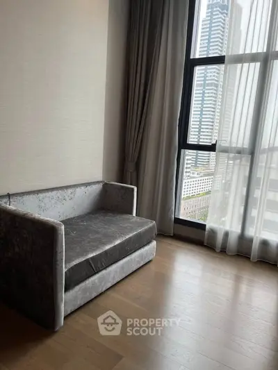 Modern living room with city view and elegant sofa near large window.