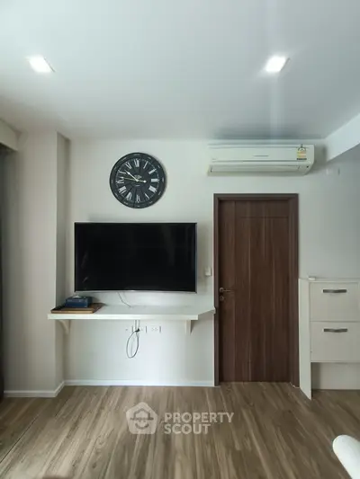 Modern living room with wall-mounted TV and air conditioning unit