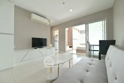 Modern living room with sleek furniture and open balcony access