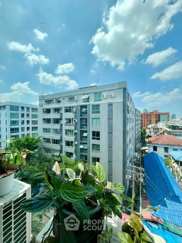 Urban apartment building view with lush greenery and clear blue sky