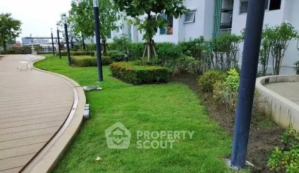 Lush green garden area with modern walkway in residential complex