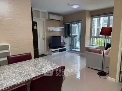 Modern living room with dining area, TV, and large window in a stylish apartment.
