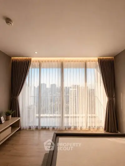 Luxurious bedroom with floor-to-ceiling windows offering stunning city views and elegant curtains.