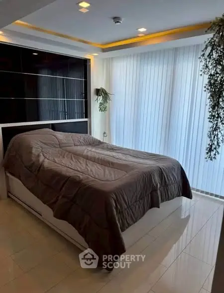 Modern bedroom with sleek design and large windows for natural light.