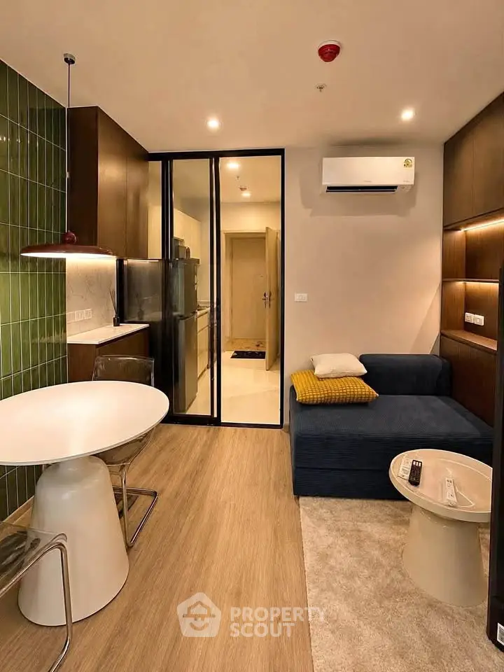 Modern living room with stylish furniture and open kitchen layout in a cozy apartment.