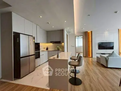 Modern open-layout kitchen and living room with sleek design and stylish furnishings.