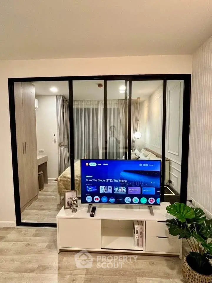 Modern living room with TV and glass partition to bedroom, stylish decor