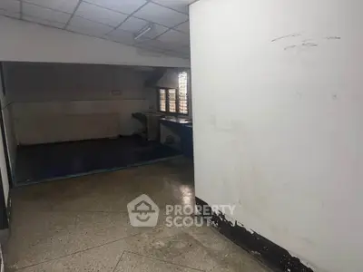 Spacious interior with tiled walls and large windows, ideal for renovation or creative use.