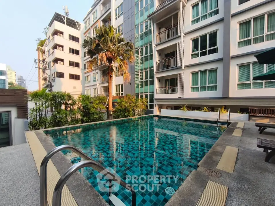 Modern apartment building with a luxurious outdoor pool and lush greenery.