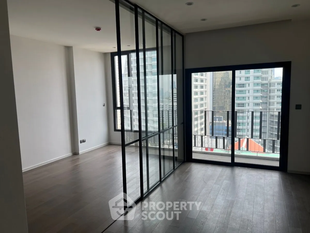 Modern apartment with floor-to-ceiling windows and city view, featuring sleek glass partitions.