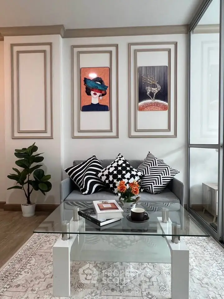 Stylish living room with modern decor, glass coffee table, and chic wall art.