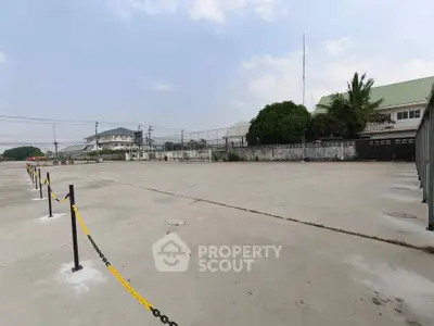 Spacious outdoor parking area with clear sky and surrounding buildings, ideal for commercial use.