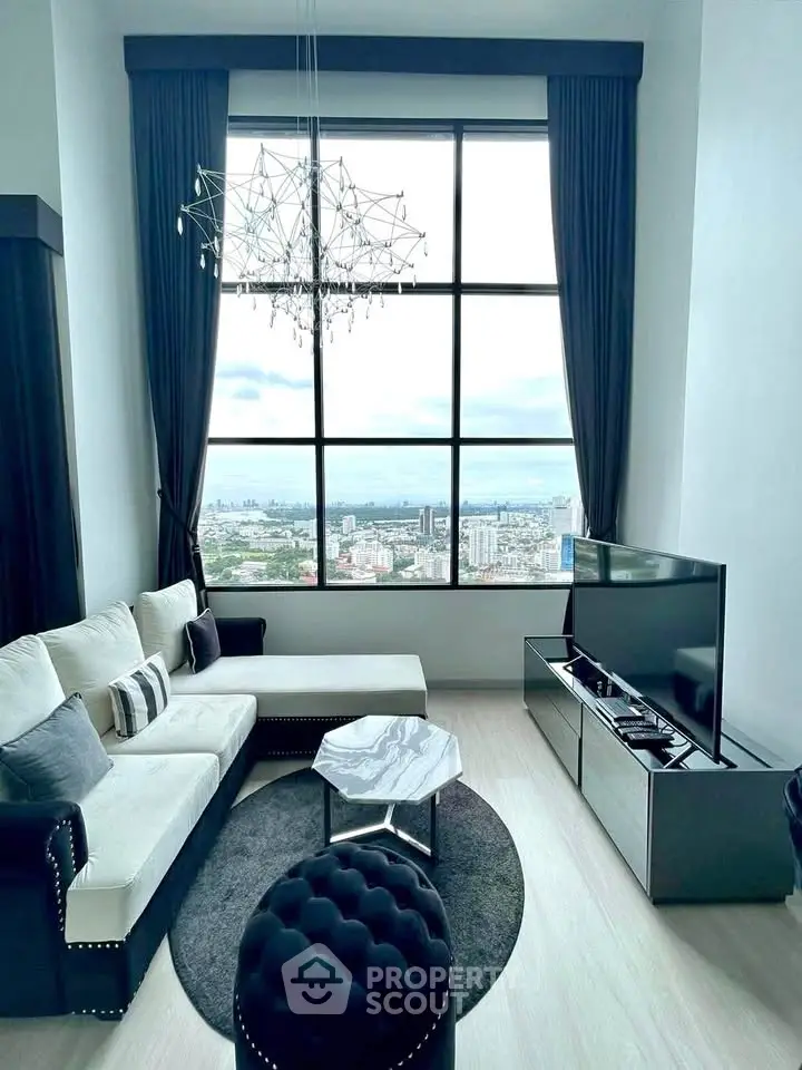 Luxurious living room with stunning city view, elegant chandelier, and modern furnishings.