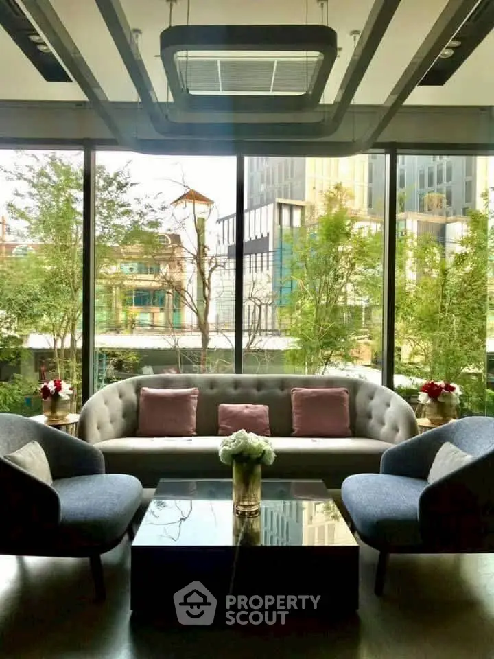 Luxurious living room with modern furniture and large windows offering a stunning city view.