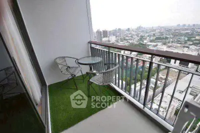 Stunning city view from a modern balcony with seating area.