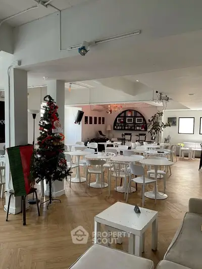 Spacious modern living area with festive decor and ample seating, perfect for gatherings.