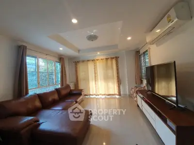 Spacious living room with modern leather sofa and large TV unit