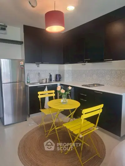Chic modern kitchen with vibrant yellow dining set and sleek black cabinetry.