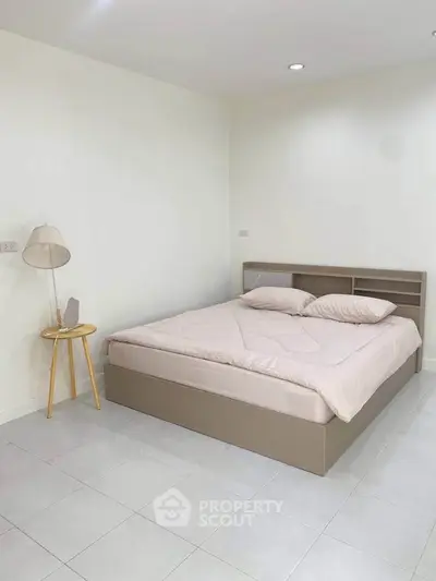 Spacious minimalist bedroom with modern bed and soft lighting
