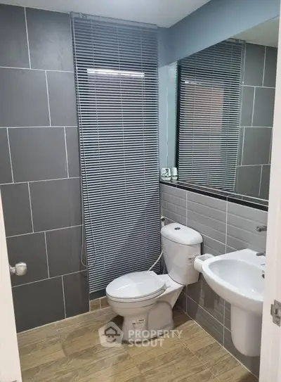 Modern bathroom with sleek gray tiles and contemporary fixtures.