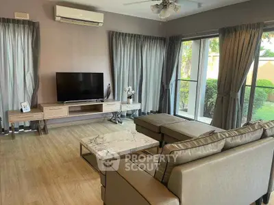 Stylish living room with modern furniture and garden view, featuring a cozy sectional sofa and sleek entertainment unit.