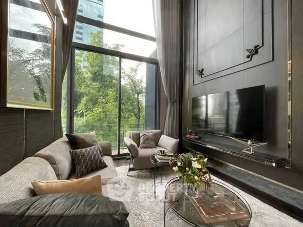 Luxurious living room with high ceilings and large windows offering a stunning view of greenery.