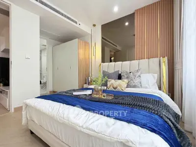 Luxurious bedroom with elegant decor and plush bedding in modern apartment.