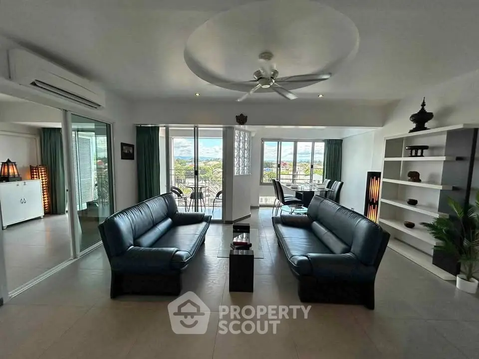 Spacious modern living room with elegant decor and large windows offering stunning views.