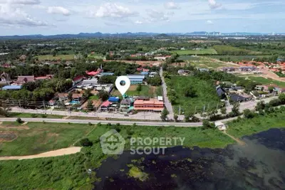 Aerial view of expansive land with potential for development, surrounded by lush greenery and scenic landscape.