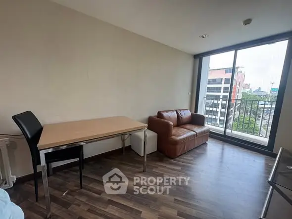 Modern living room with leather sofa and city view balcony, perfect for urban living.